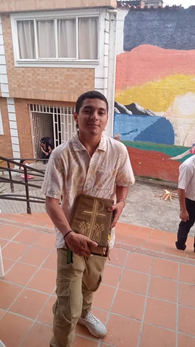 Joven sosteniendo una Biblia en el patio de la finca