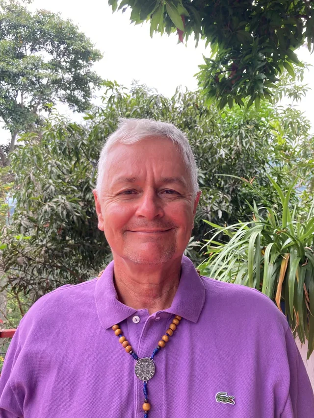 Oscar Rosas sonriendo con su rosario en la finca de Floridablanca